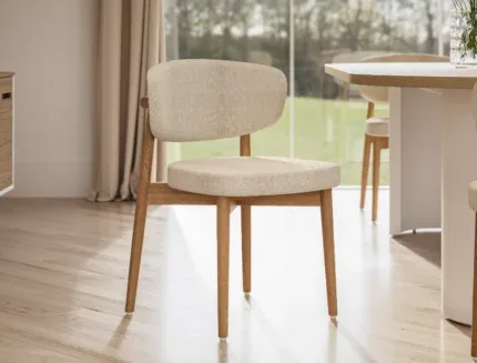 Elegant Scandinavian dining chair with a padded upholstered seat, natural wood legs, and contemporary styling for modern interiors.