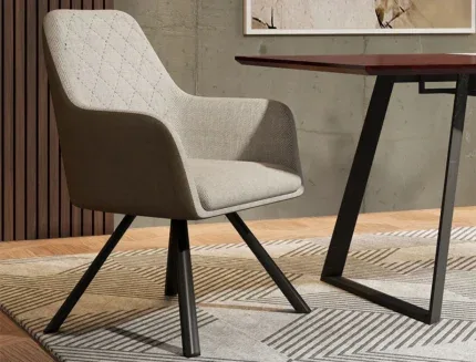 Contemporary fabric dining chair featuring a wraparound backrest, padded seat, and durable black metal legs in a modern dining room.