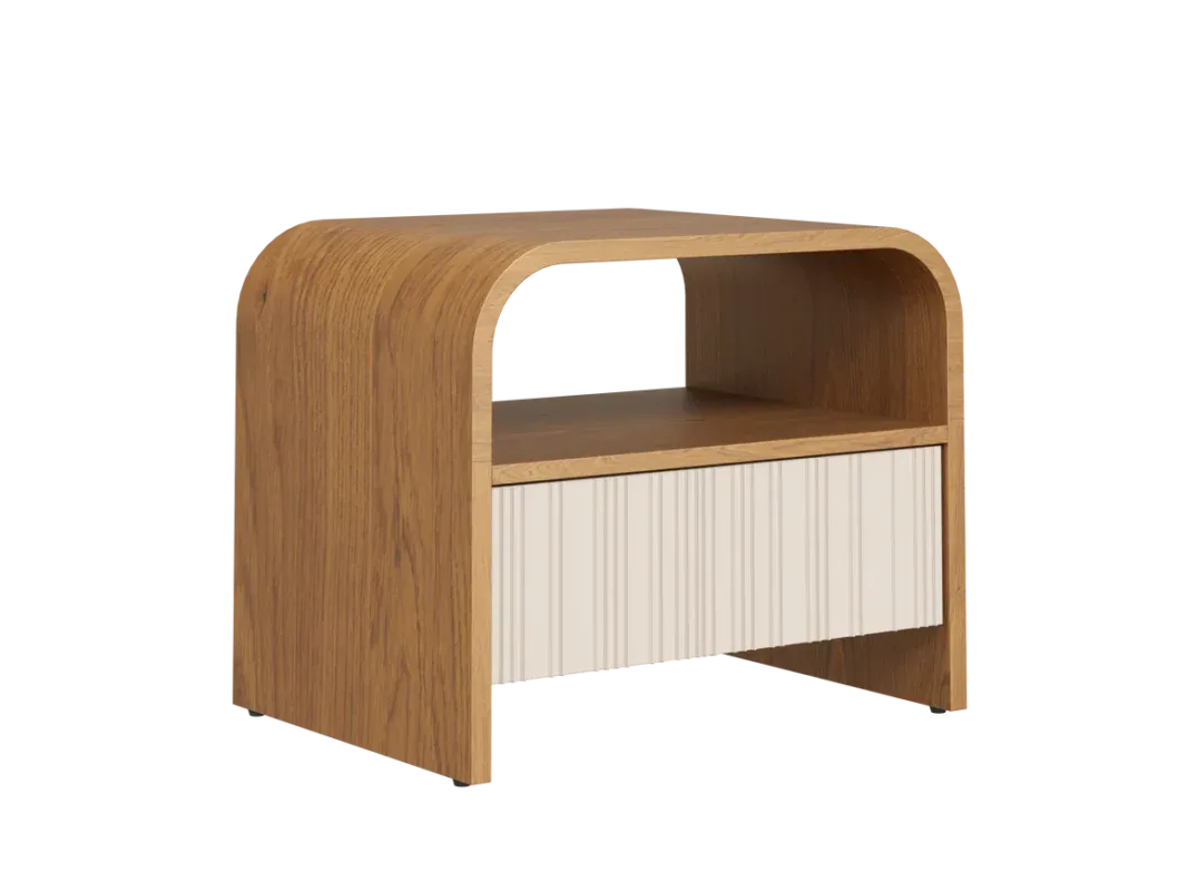 Modern curved wooden bedside table with fluted drawer and open shelf beside an upholstered bed.