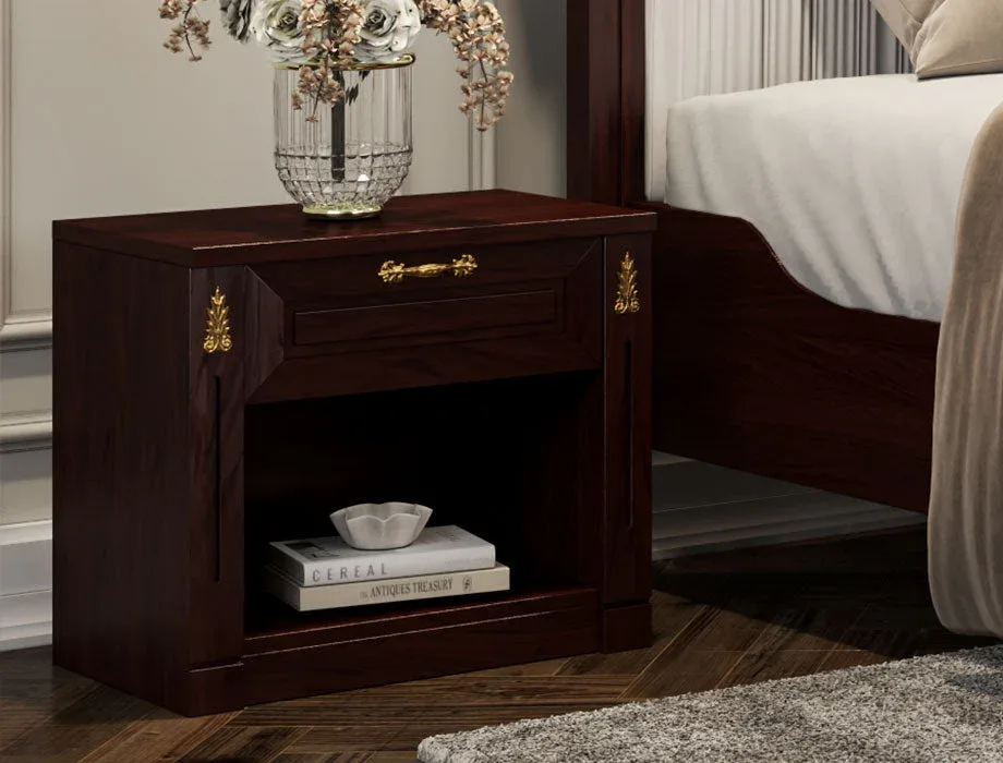 Classic walnut wooden bedside table with drawer and open storage shelf beside a luxury bed.