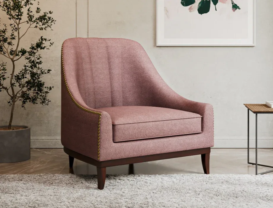 Modern fabric lounge chair featuring blush pink upholstery, a padded seat, curved backrest, and solid wood legs.