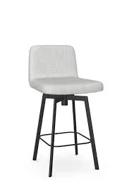Modern upholstered fabric bar stool with black metal legs beside a contemporary wooden workspace and brick wall background.